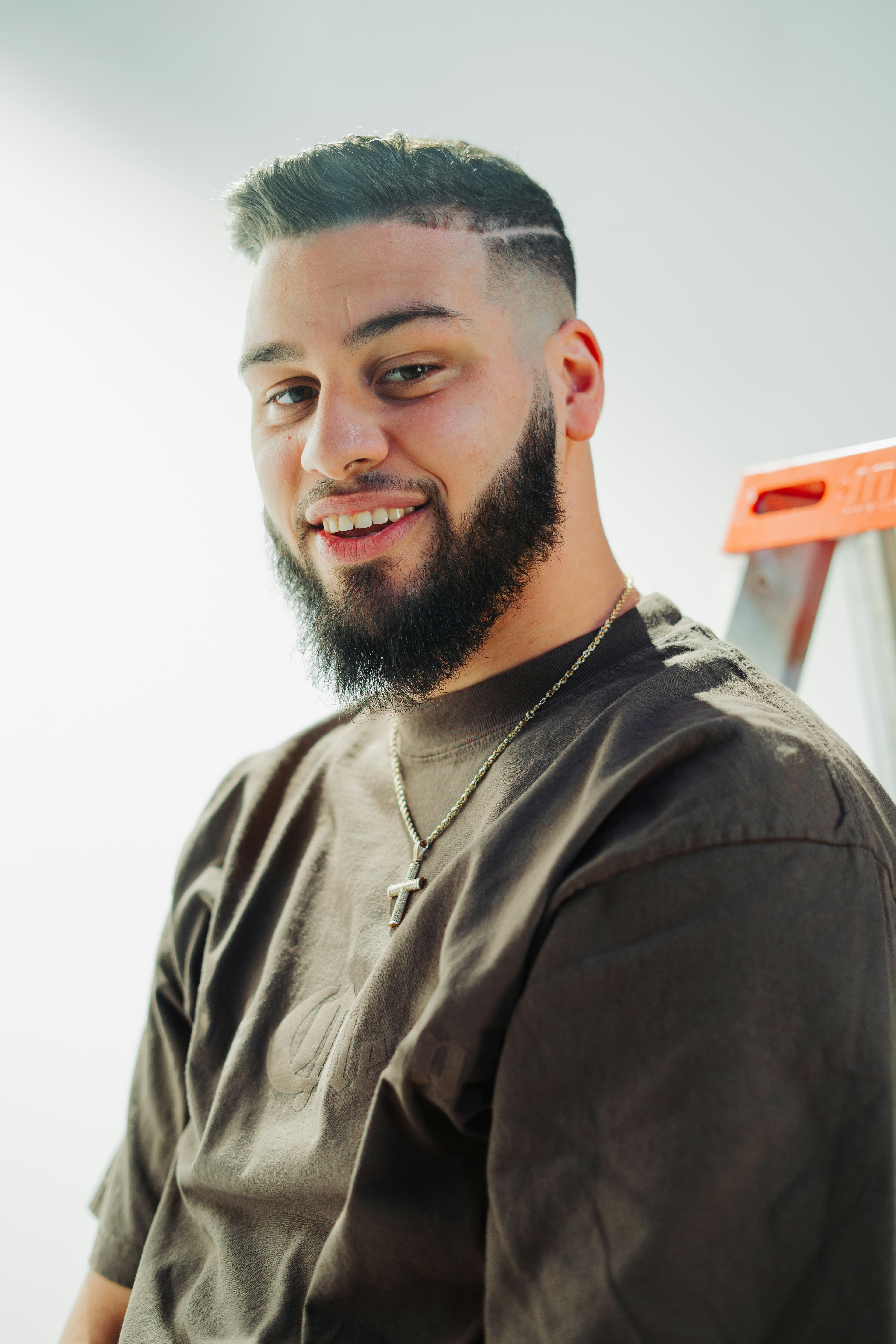 A tradesman beside a ladder, smiling